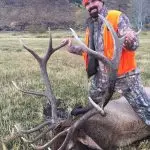 Bill Busbice poses with a bull elk killed on his ranch in Wyoming